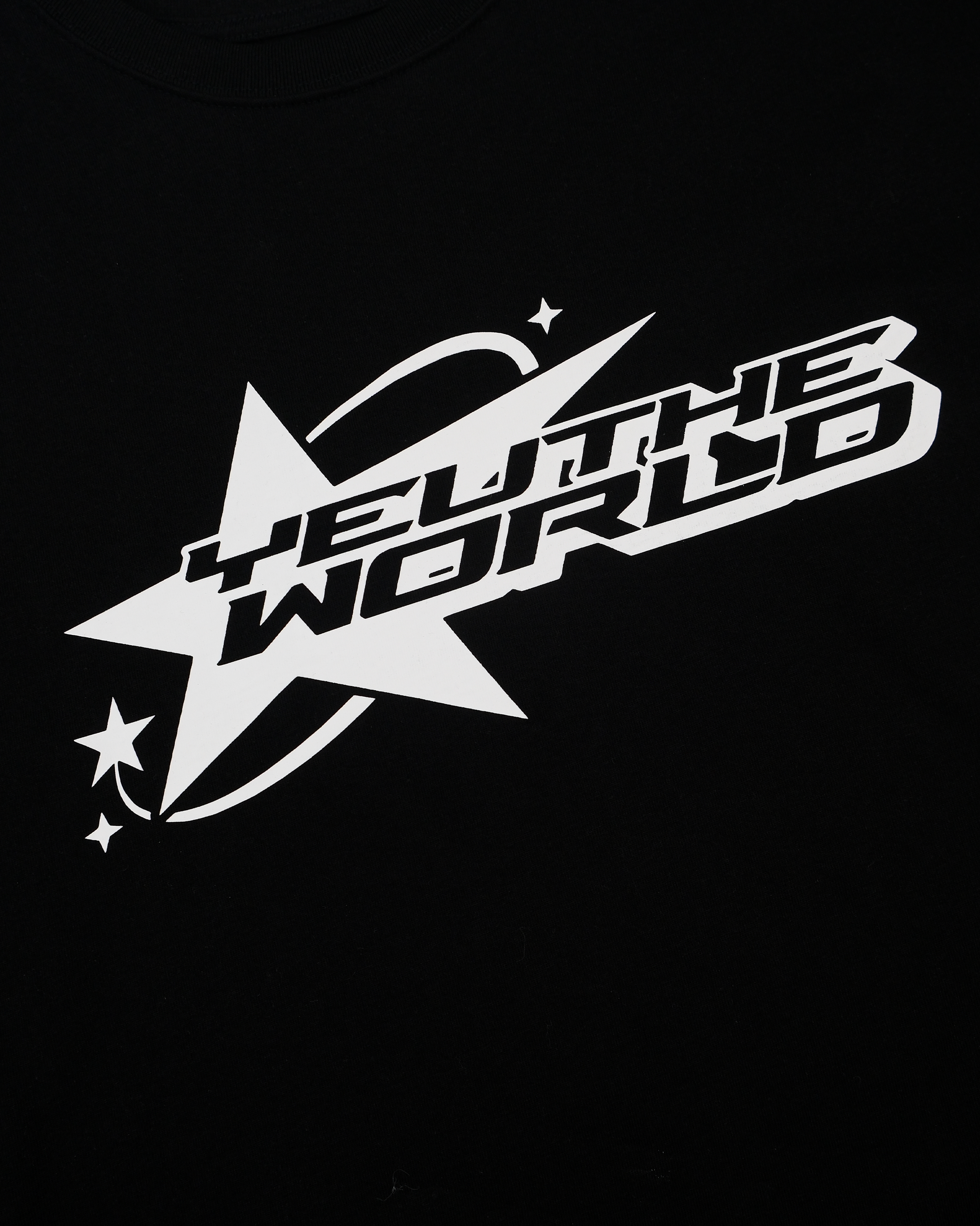 Nahaufnahme eines schwarzen T-Shirts mit weißem Frontprint. Das Motiv zeigt einen großen Stern, durchzogen vom Schriftzug „YEU THE WORLD“ in futuristischer Blockschrift. Um den Stern verlaufen drei kleine Sternsymbole und eine gebogene Linie, die an eine Flugbahn erinnert