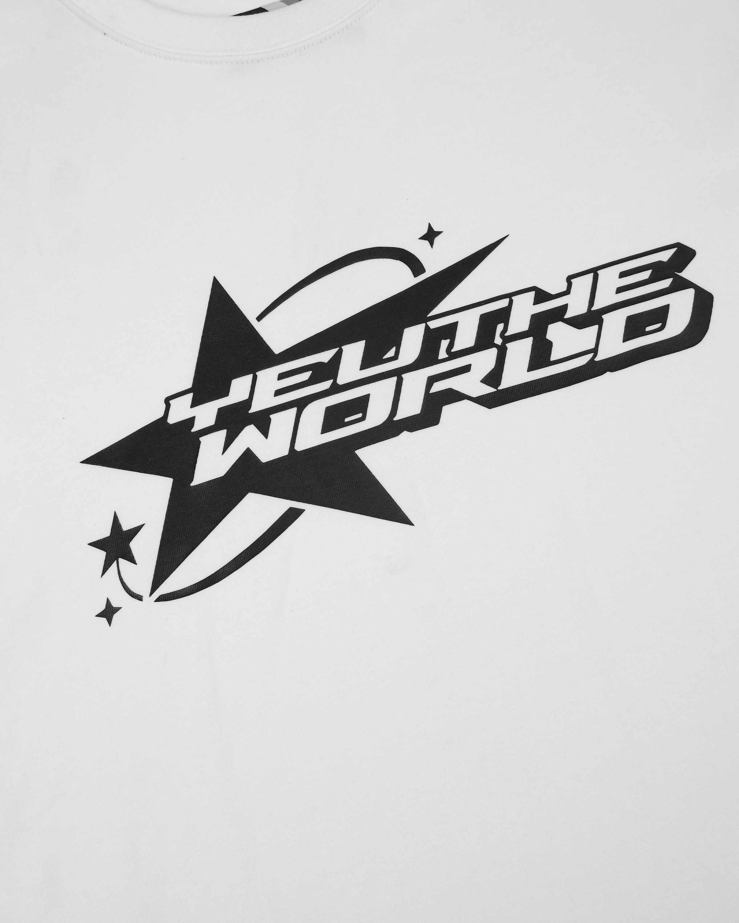 Nahaufnahme des Frontprints auf weißem Stoff. Schwarze Illustration bestehend aus einem großen Stern mit drei kleinen Sternen links unten. Zentraler Schriftzug: „YEU THE WORLD“ in kastenförmiger Typografie mit Bogenlinie und Glanzeffekt-Optik.