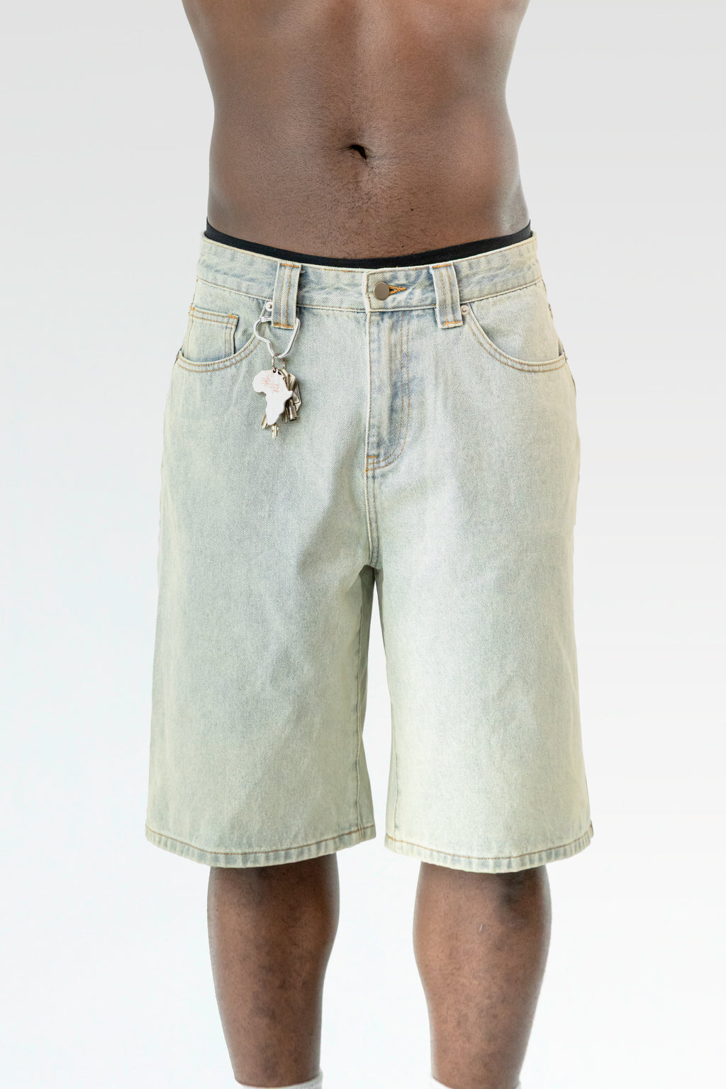 Nahaufnahme der hellblauen Bermuda-Shorts im getragenen Zustand, mit Fokus auf den Karabinerhaken samt Schlüsselbund an der Gürtelschlaufe.