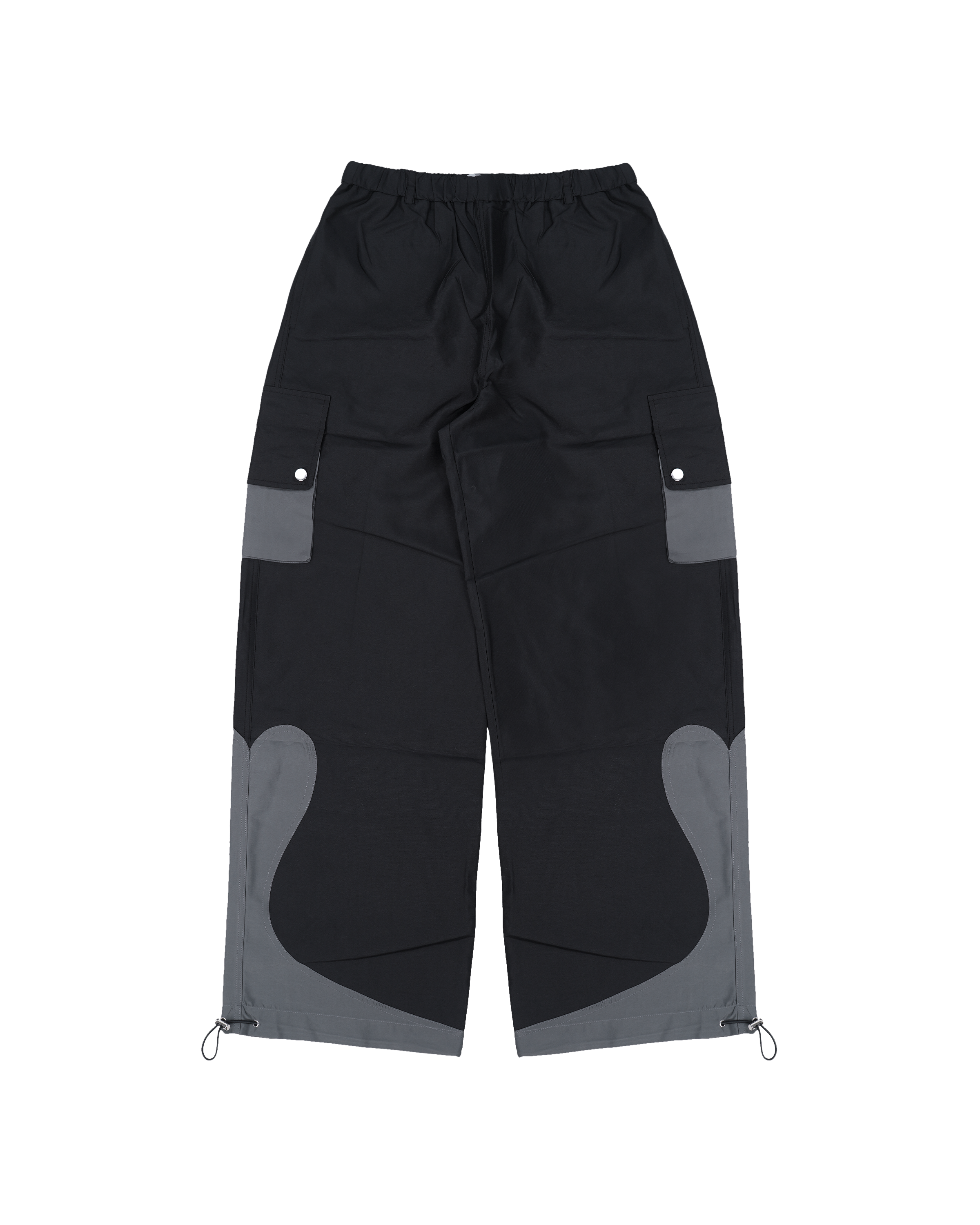 Vorderansicht der gleichen Hose, ebenfalls freigestellt. Sichtbar sind die aufgesetzten Cargotaschen an den Seiten mit grauen Elementen sowie die geschwungenen, zweifarbigen Einsätze an den unteren Beinpartien. Der Schnitt ist weit und sportlich, mit funktionalem Design.