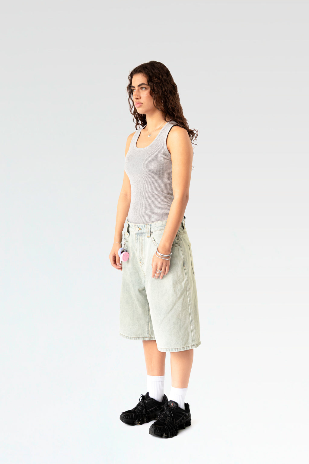 Schräg seitliche Ansicht der hellblauen Bermuda-Shorts an einer stehenden Person. Die weite Beinform und die klassische 5-Pocket-Optik sind gut sichtbar.