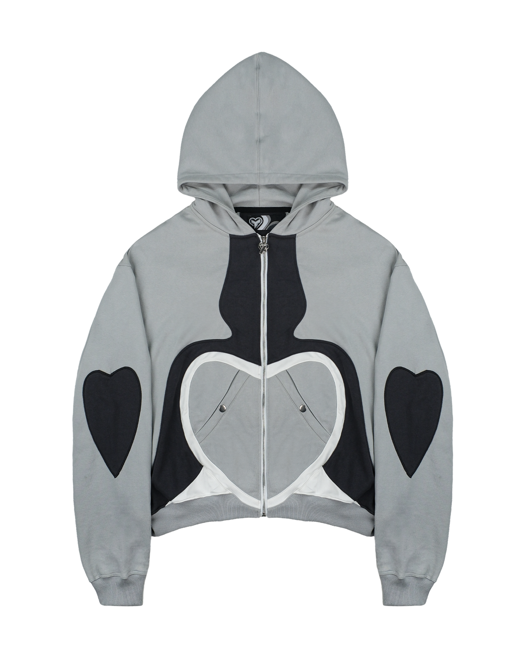 Nahaufnahme der Hoodie-Vorderseite mit zentralem Zipper, schwarzem Herzdesign mit weißen Rändern sowie zwei seitlich integrierten Druckknopftaschen im unteren Brustbereich.