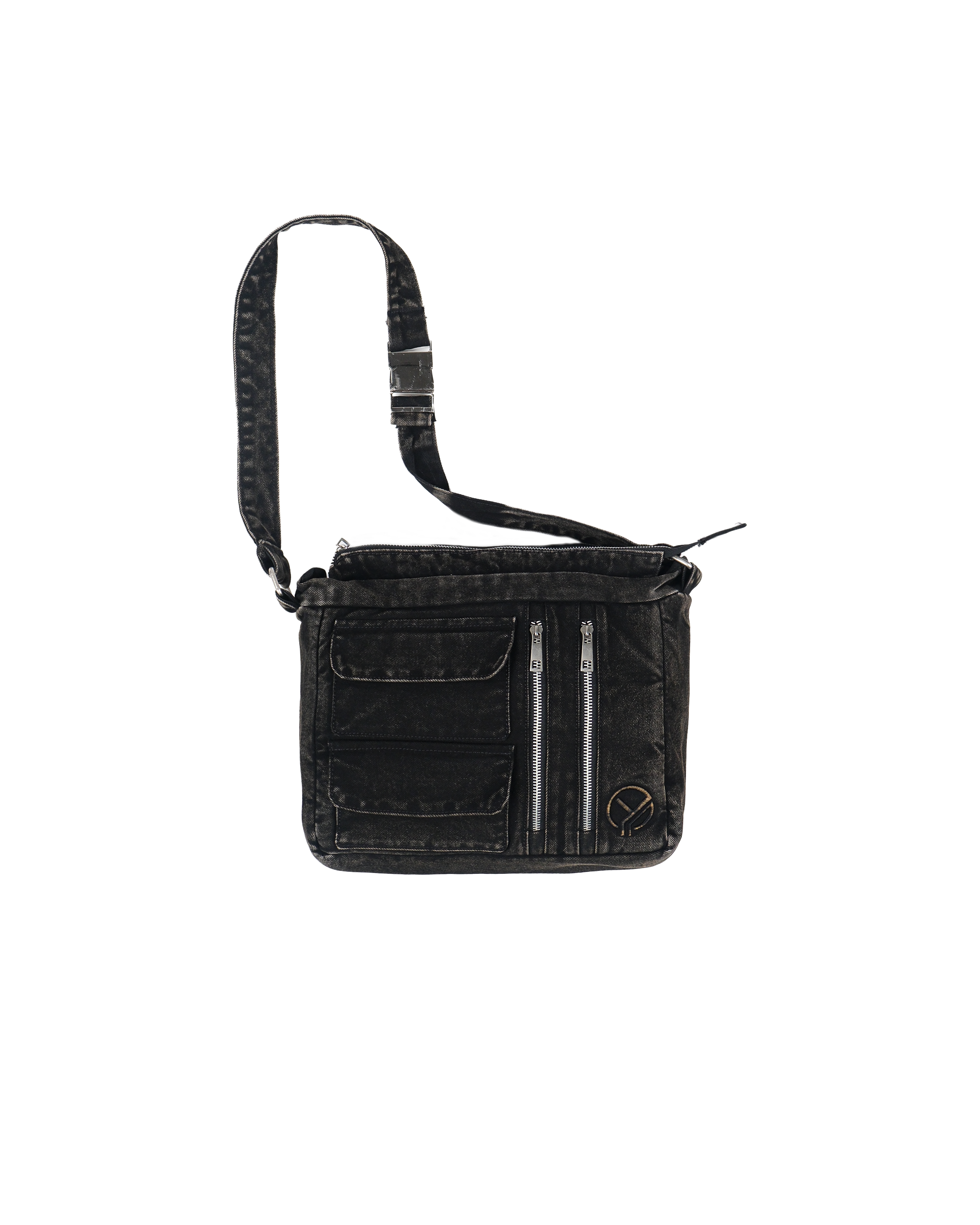 Freigestelltes Produktbild einer größeren Umhängetasche aus schwarzem, gewaschenem Denim mit mehreren Taschen und zwei silberfarbenen Reißverschlüssen auf der Vorderseite. Die Tasche verfügt über einen breiten, verstellbaren Schulterriemen mit Metallschnalle und ein kleines schwarzes Sticklogo unten rechts.