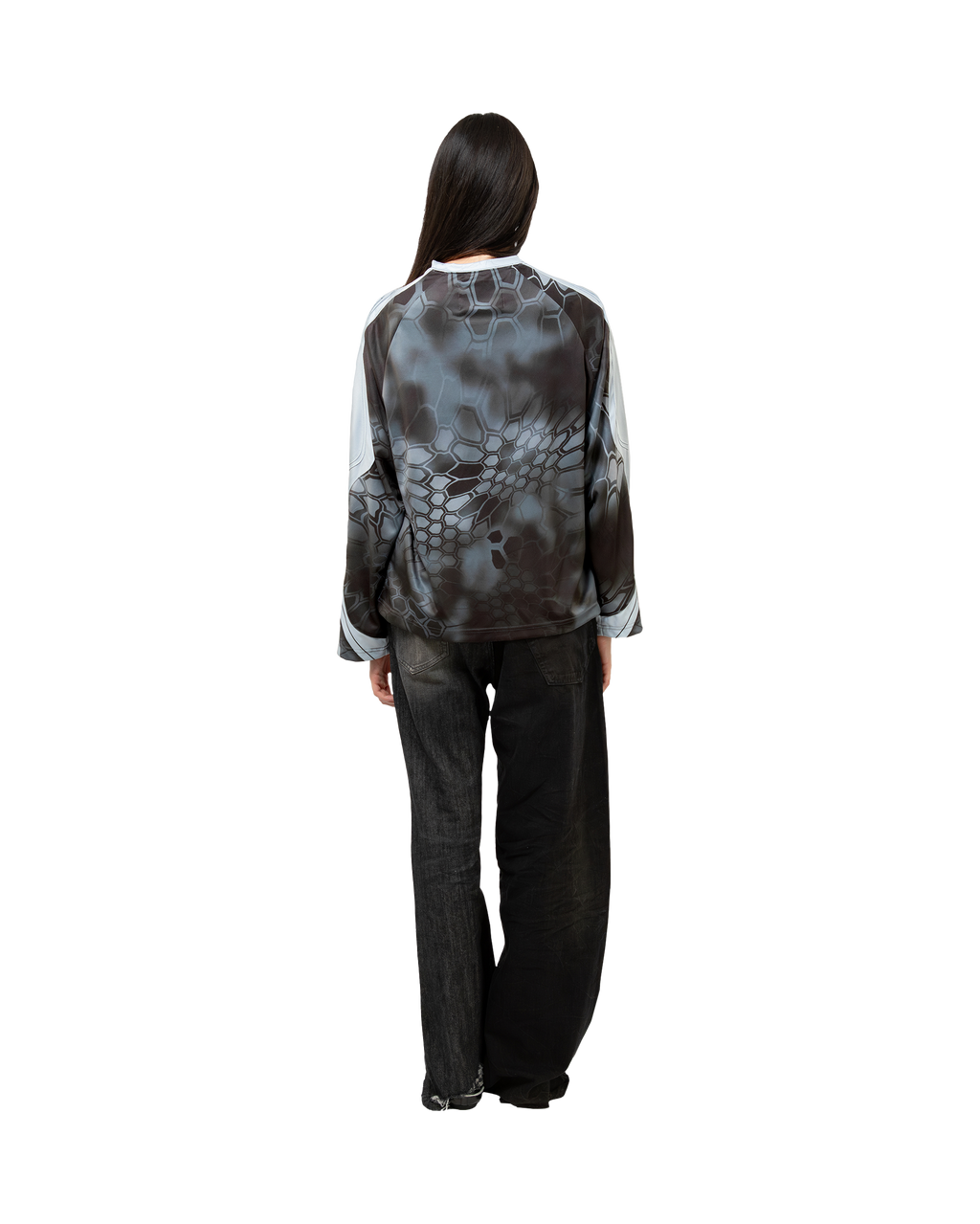 Langarm-Jersey in Schwarz-Weiß mit auffälligem Rückenmuster, getragen an Model mit weiter geschnittener Jeans.