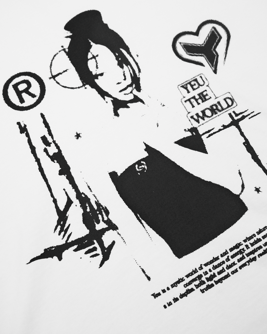 Nahaufnahme des schwarzen Frontprints auf weißem T-Shirt. Im Fokus steht die grafische Darstellung einer Frau mit hochgestecktem Haar, kombiniert mit Symbolen wie Herzlogo, Zielkreis und Schriftzug „YEU THE WORLD“. Der Druck weist eine körnige, stempelartige Textur auf.

