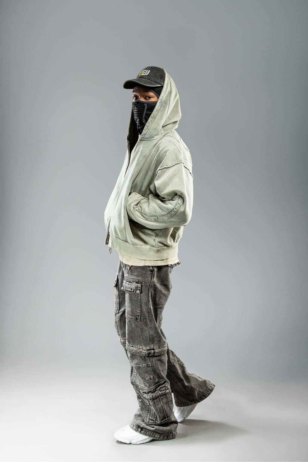 Seitenansicht mit Cap und Maske: Hoodie in stylishem Kontext getragen, seitliches Volumen betont.