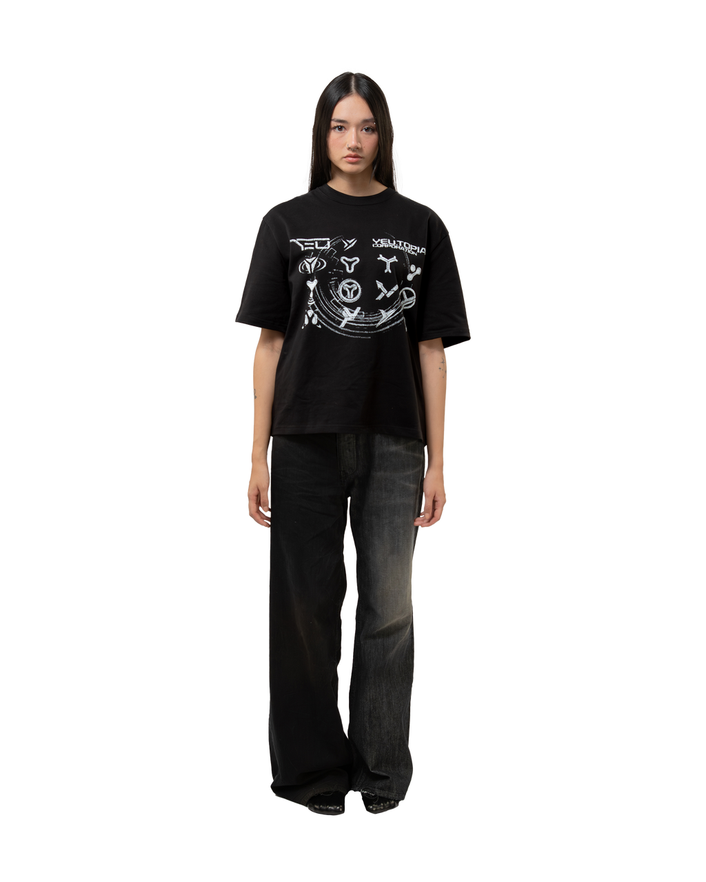 Locker geschnittenes, schwarzes T-Shirt mit großem, zentral platziertem Print in Rosa und Weiß. Getragen mit weitem Jeansmodell im Used-Look.