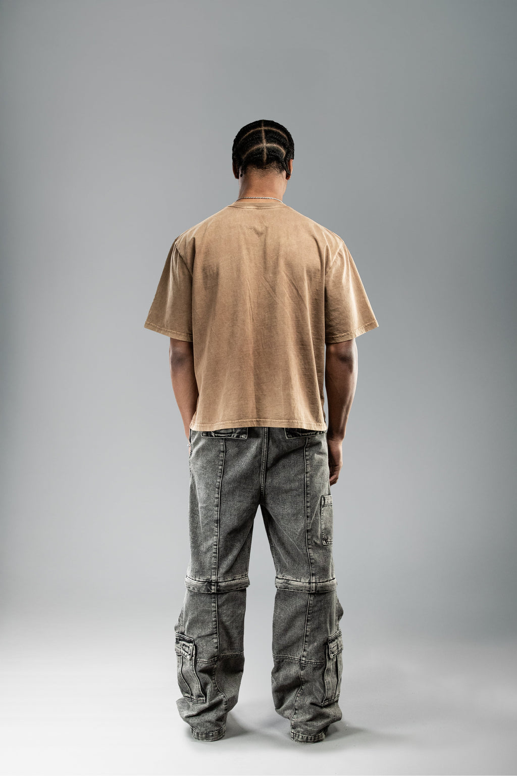 Rückansicht eines braunen T-Shirts ohne Aufdruck, getragen. Der Stoff weist eine leicht verwaschene Optik auf.