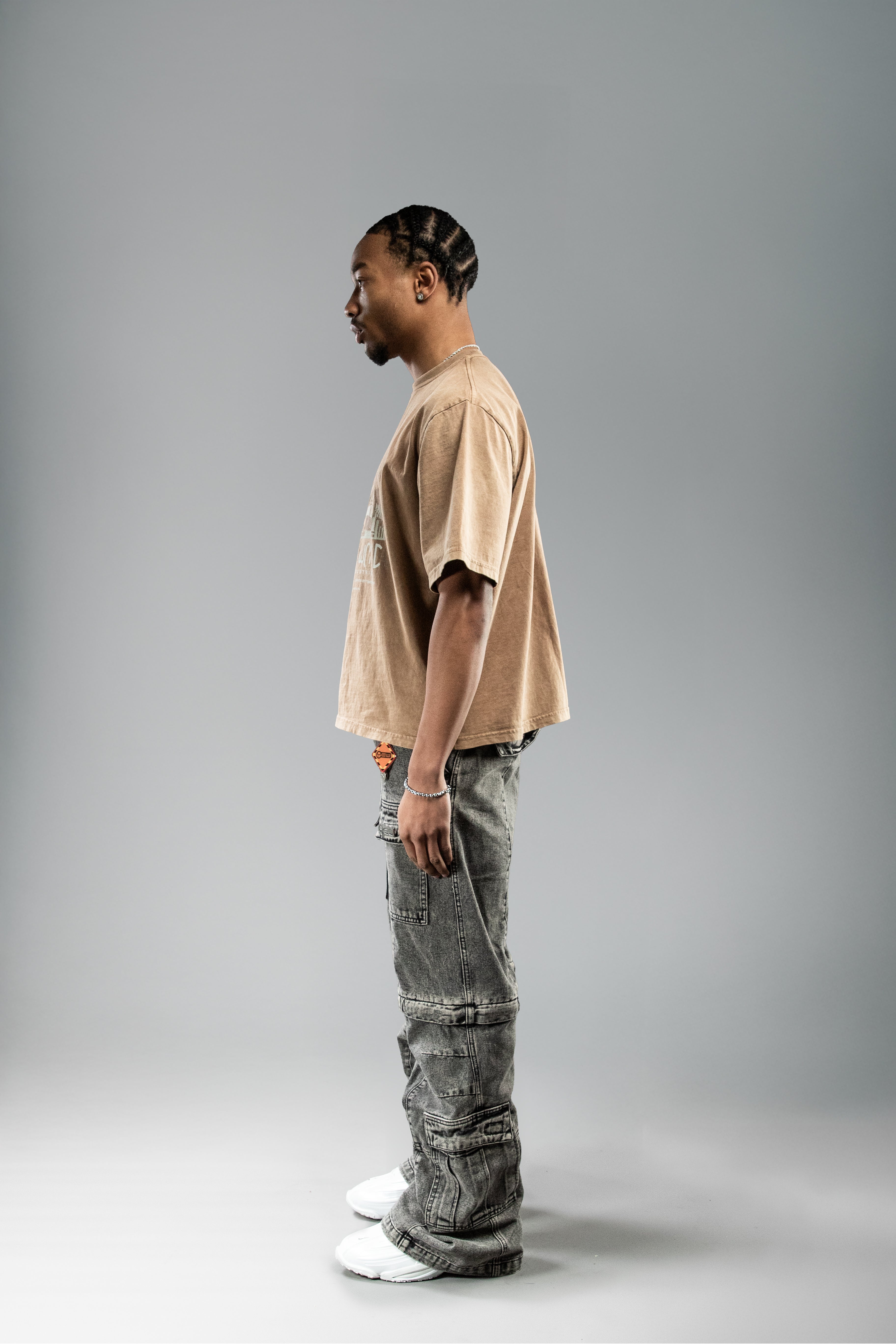 Seitenansicht eines braunen T-Shirts mit urbanem Frontprint in hellem Beige und Hellblau. Der Rücken ist unbedruckt.