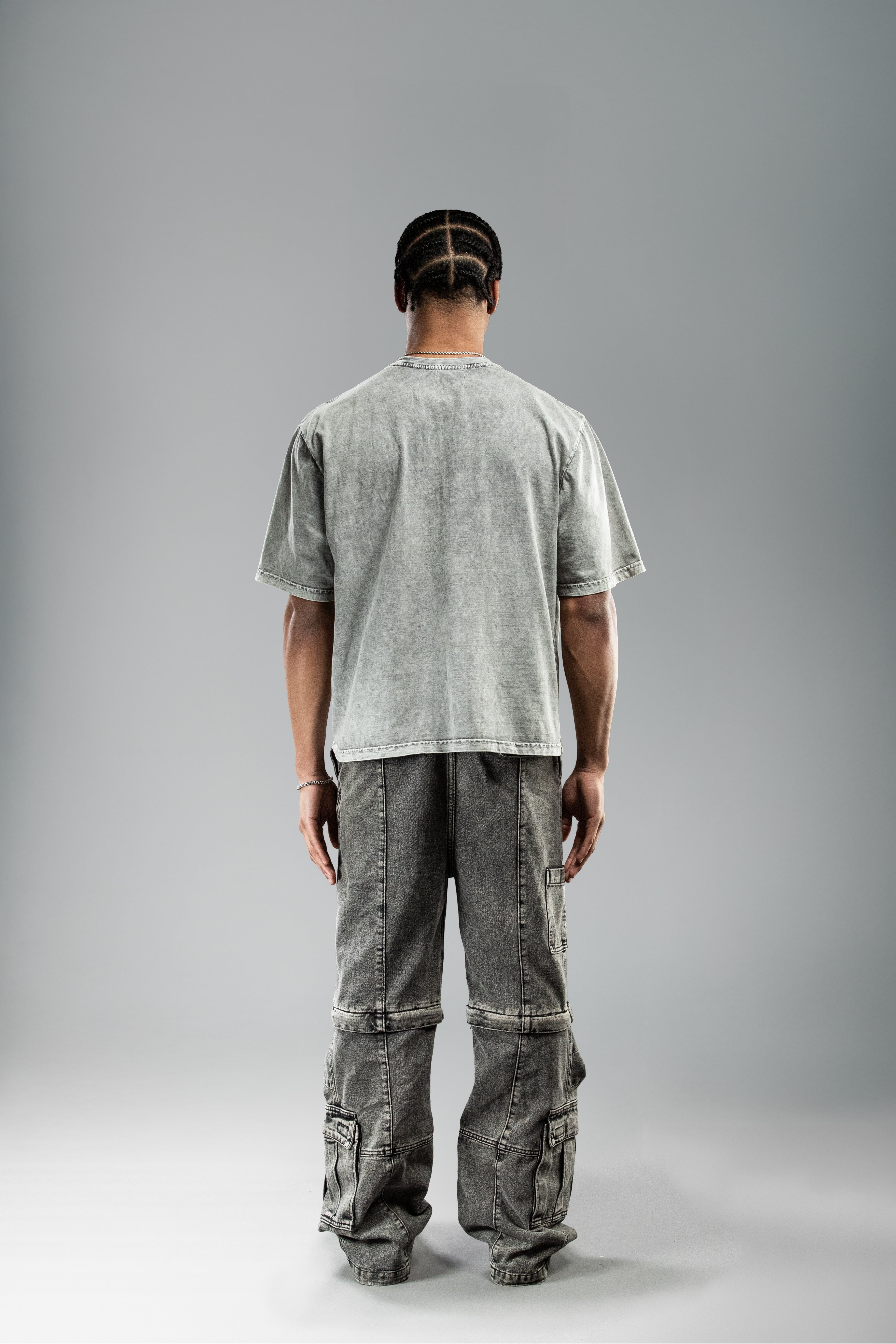 Rückansicht des grauen Shirts, schlicht und unbedruckt, mit sichtbaren Waschspuren.