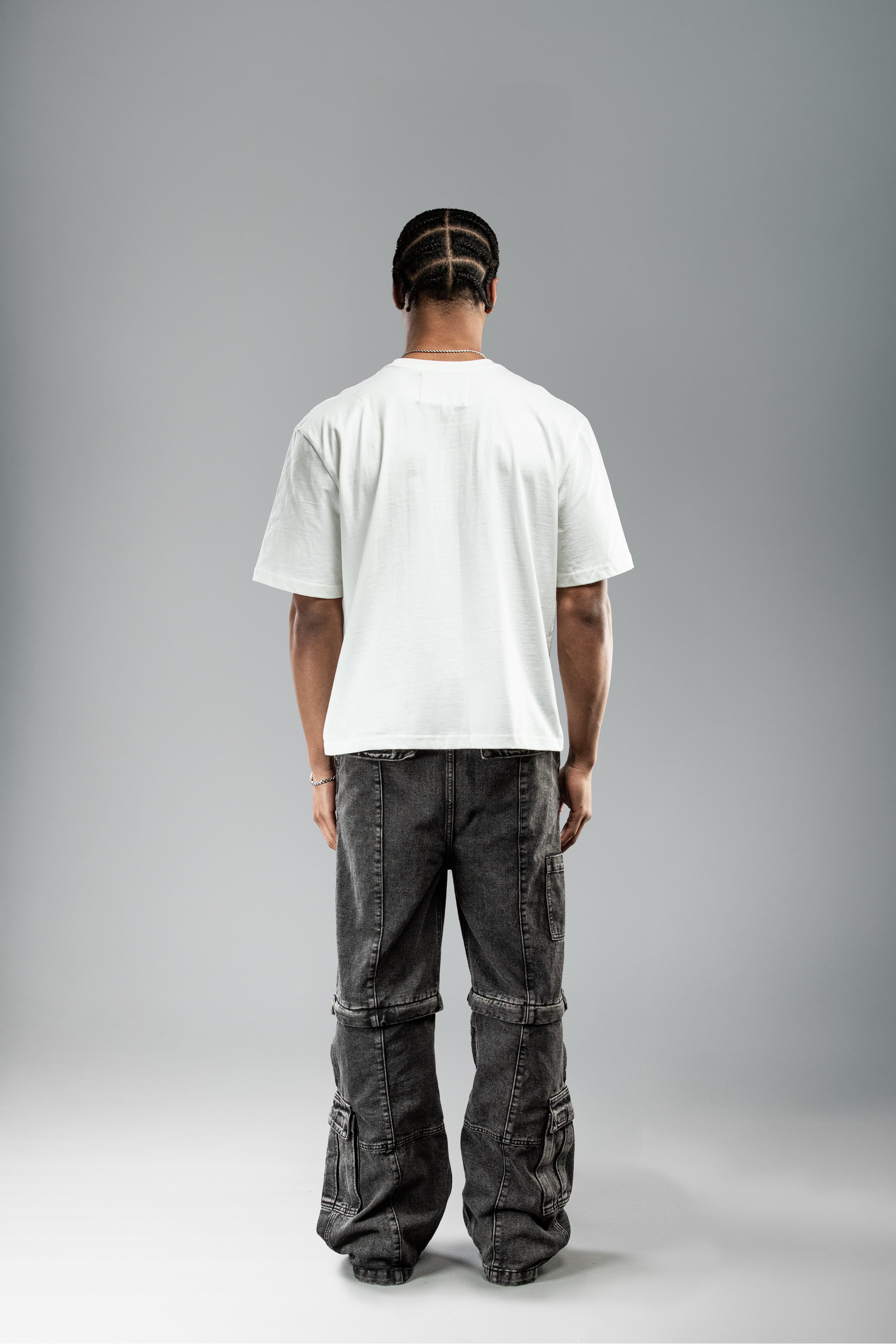 Weißes T-Shirt ohne Rückendruck, getragen von hinten gezeigt. Schlichtes Design mit geradem Schnitt und leicht überschnittenen Schultern.
